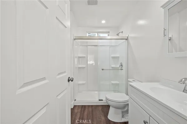 a bathroom with a granite countertop toilet a sink and shower