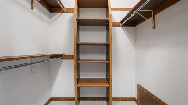 a view of walk in closet with clothes and window