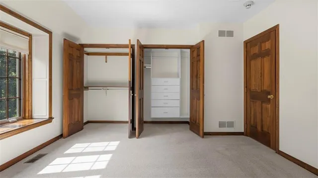 a view of empty room with windows and refrigerator