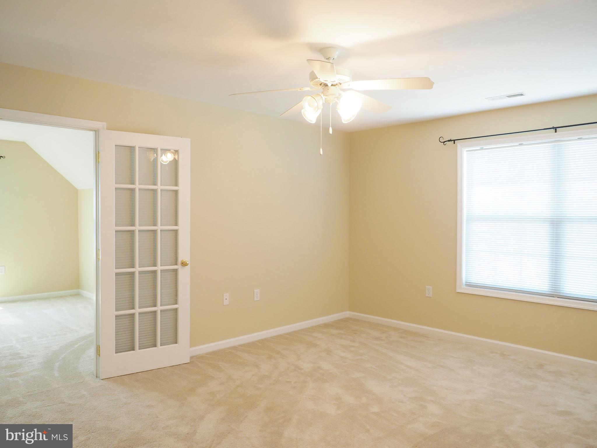 18 Solara Court Inwood, WV 25428 - Photo 13 of 24 an empty room with windows and chandelier fan