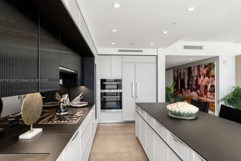 a kitchen with stainless steel appliances kitchen island granite countertop a stove and white cabinets
