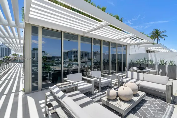 a view of a patio with couches table and chairs and potted plants