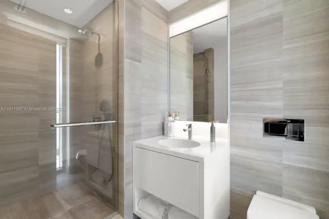 a spacious bedroom with a bed and glass window