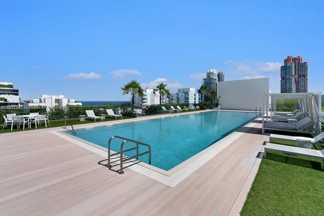 a view of a chairs and table in patio with swimming pool