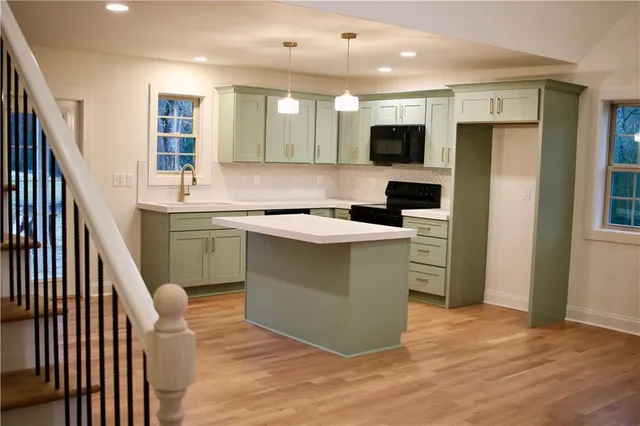 a kitchen with stainless steel appliances granite countertop a sink and a refrigerator