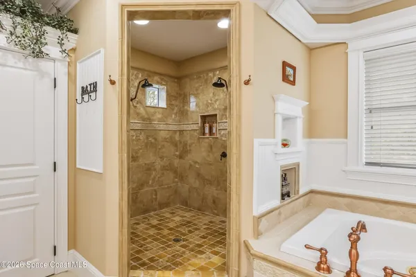 a bed sitting in a spacious bedroom next to a window