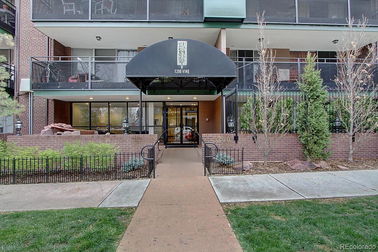 a front view of a building with a garden and plants
