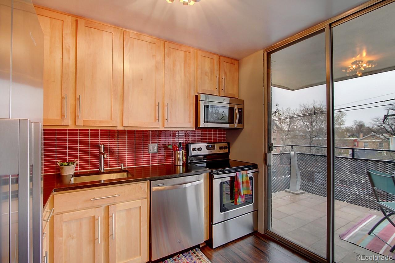 1200 Vine Street, Unit 4B Denver, CO 80206 - Photo 12 of 33 a kitchen with stainless steel appliances a stove a sink and a refrigerator