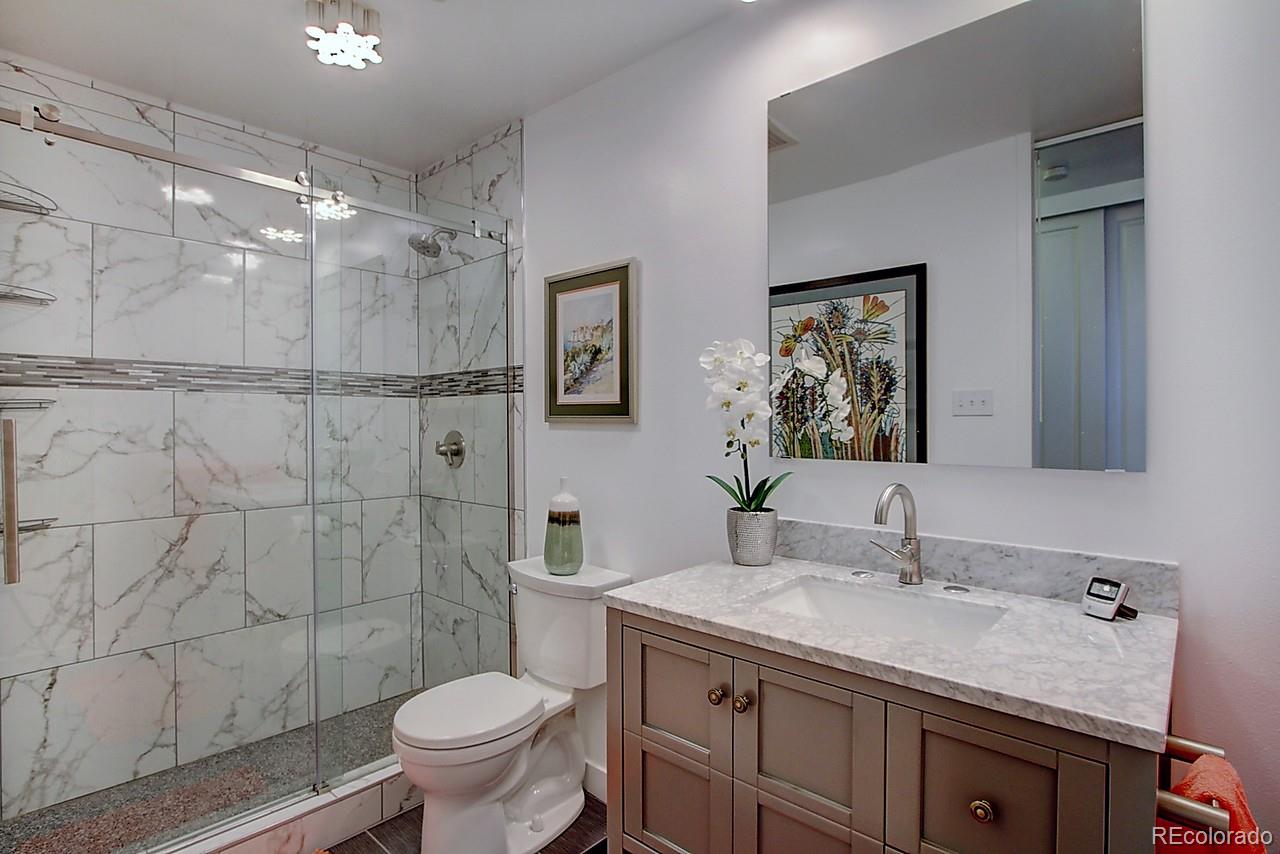 1200 Vine Street, Unit 4B Denver, CO 80206 - Photo 19 of 33 a bathroom with a granite countertop sink toilet and shower