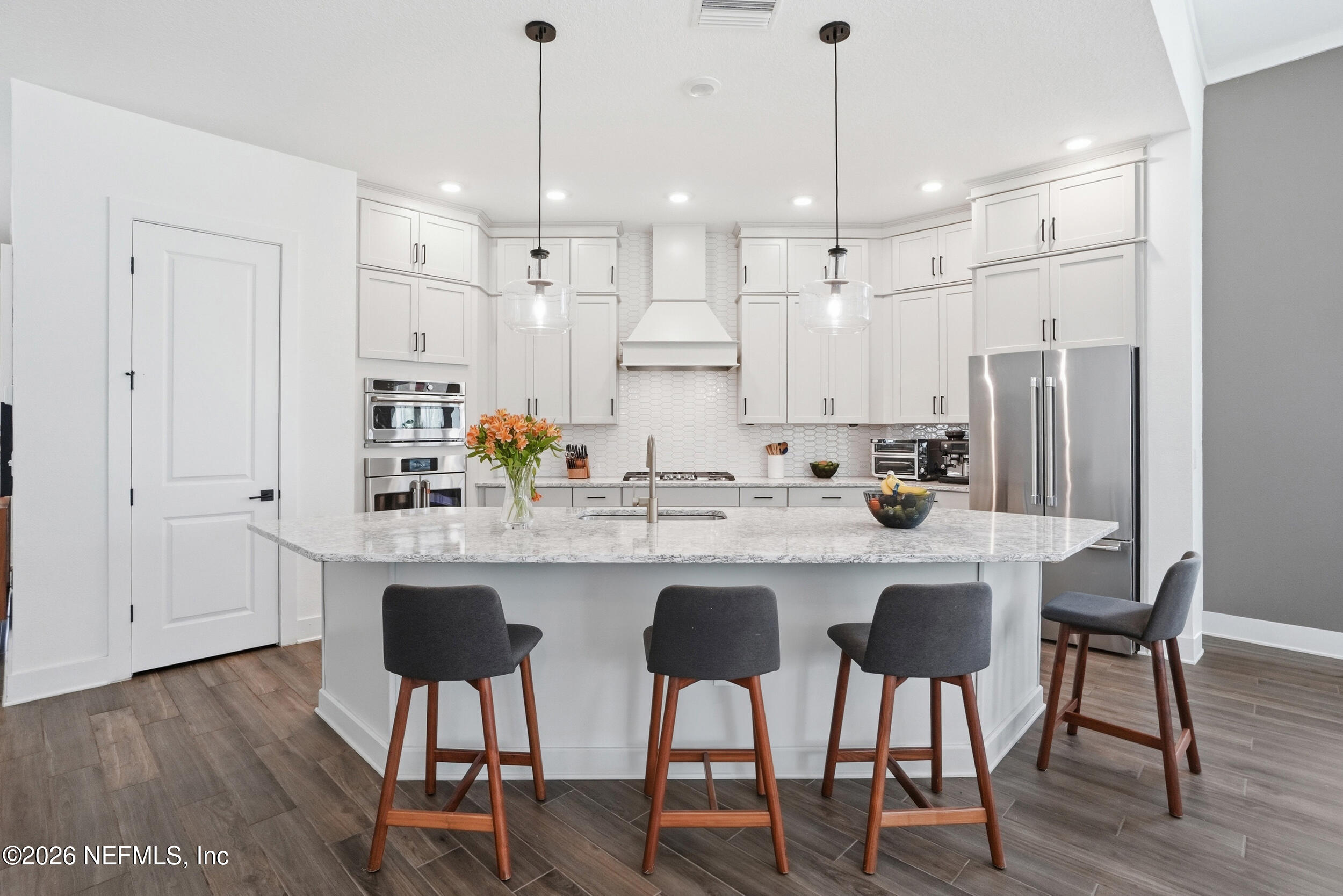 728 Navigators Road St. Johns, FL 32259 - Photo 10 of 38 a kitchen with stainless steel appliances kitchen island granite countertop a dining table chairs and white cabinets
