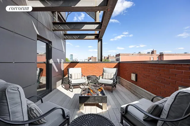 a balcony with wooden floor table and chairs