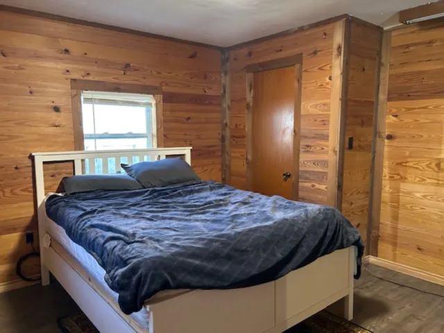 a bedroom with a bed and a window