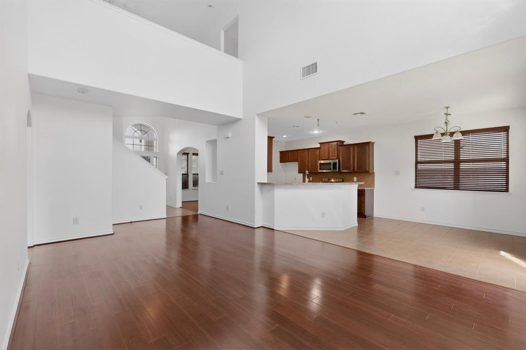 426 Harding Lane Lavon, TX 75166 - Photo 7 of 40 Spacious living area featuring wood-finish flooring, high ceilings, and a built-in kitchen island