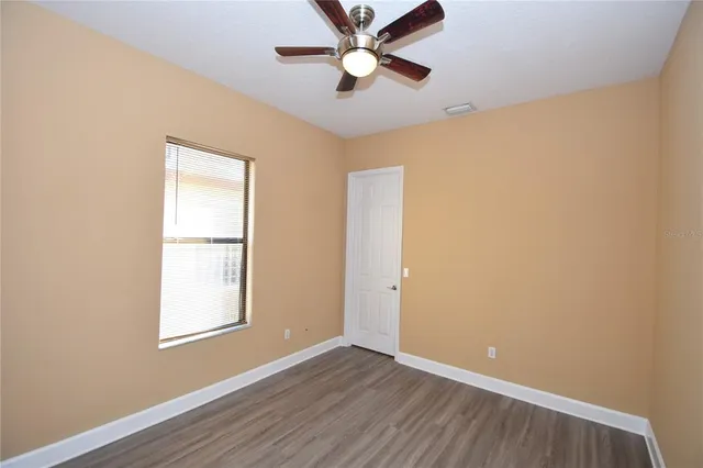 a view of an empty room with wooden floor