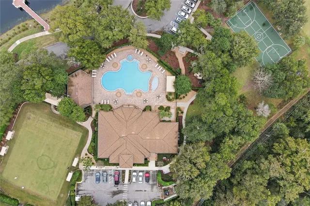 an aerial view of a house with swimming pool and a yard