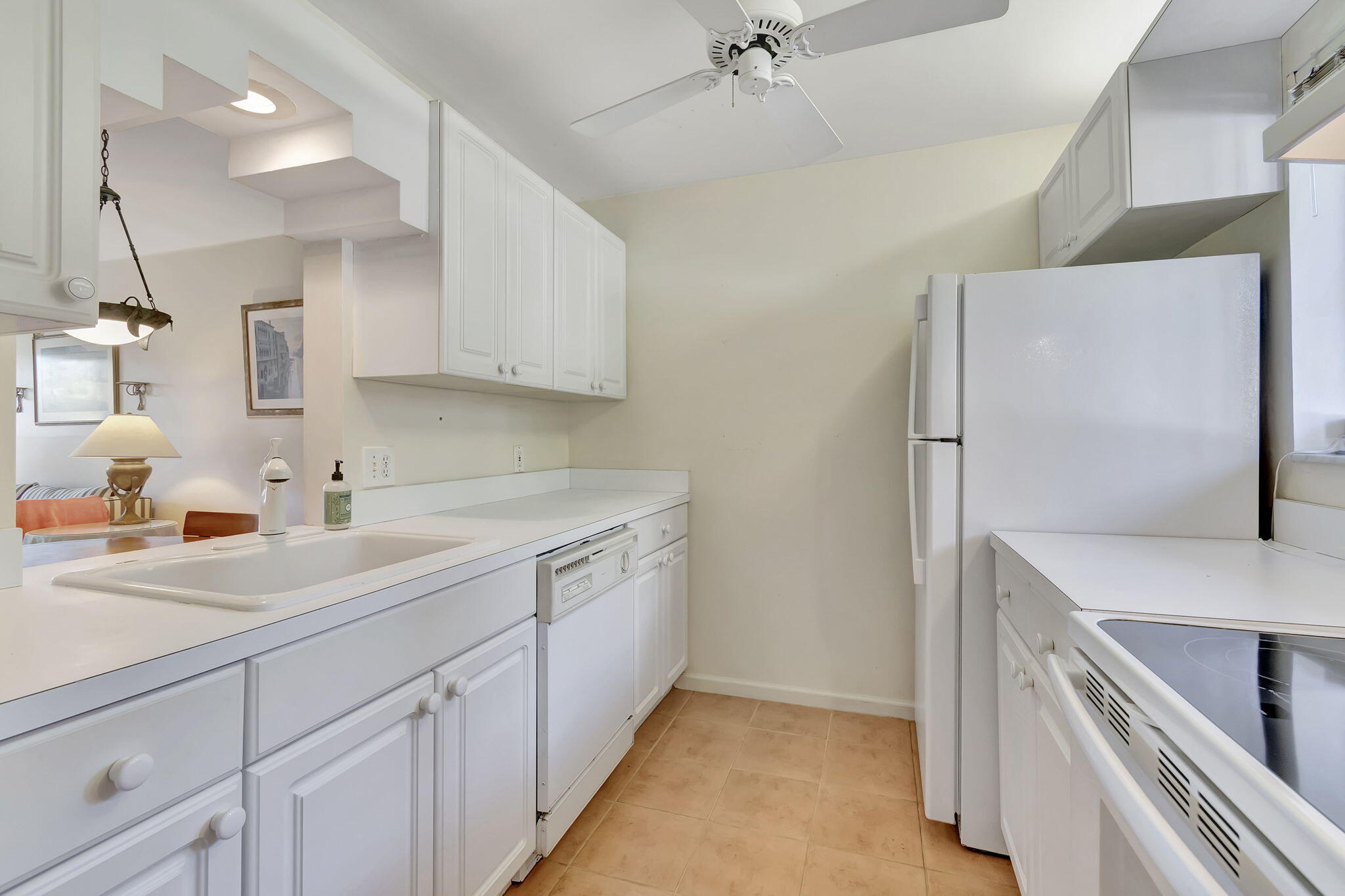 836 Southwest 9th St Circle, Unit 103 Boca Raton, FL 33486 - Photo 6 of 54 a kitchen with a sink a refrigerator and cabinets
