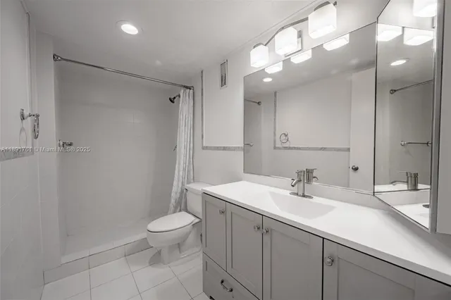 a bathroom with a sink a toilet and a large mirror