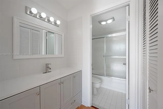 a bathroom with a sink vanity and shower