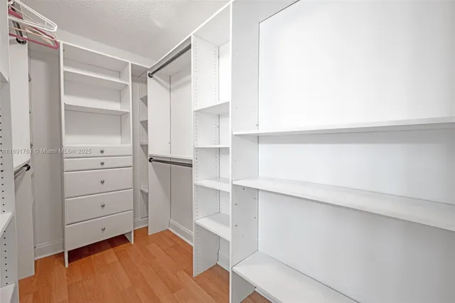 a view of walk in closet with empty racks