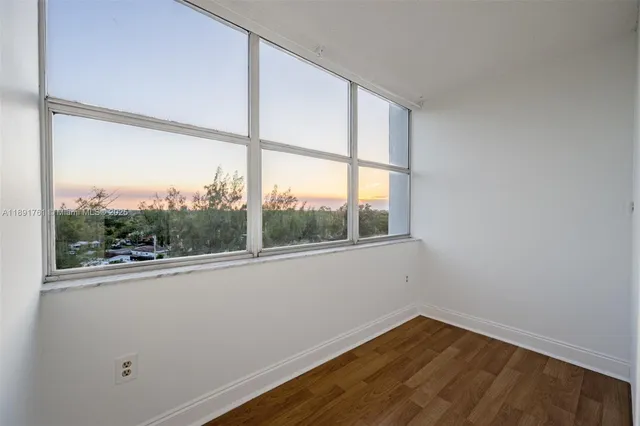a view of a room with wooden floor and a window