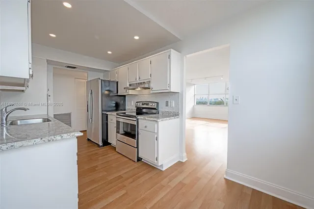 a kitchen with a sink a stove a refrigerator and a microwave