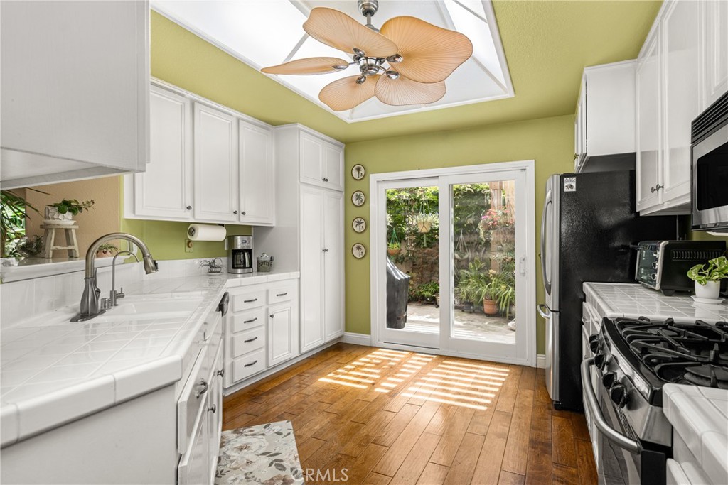 2370 Tryall Tustin, CA 92782 - Photo 11 of 36 a kitchen with granite countertop a sink stainless steel appliances and cabinets