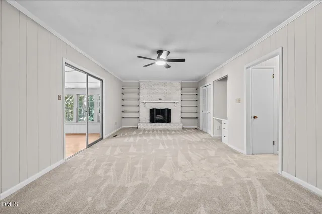 an empty room with fireplace and a ceiling fan