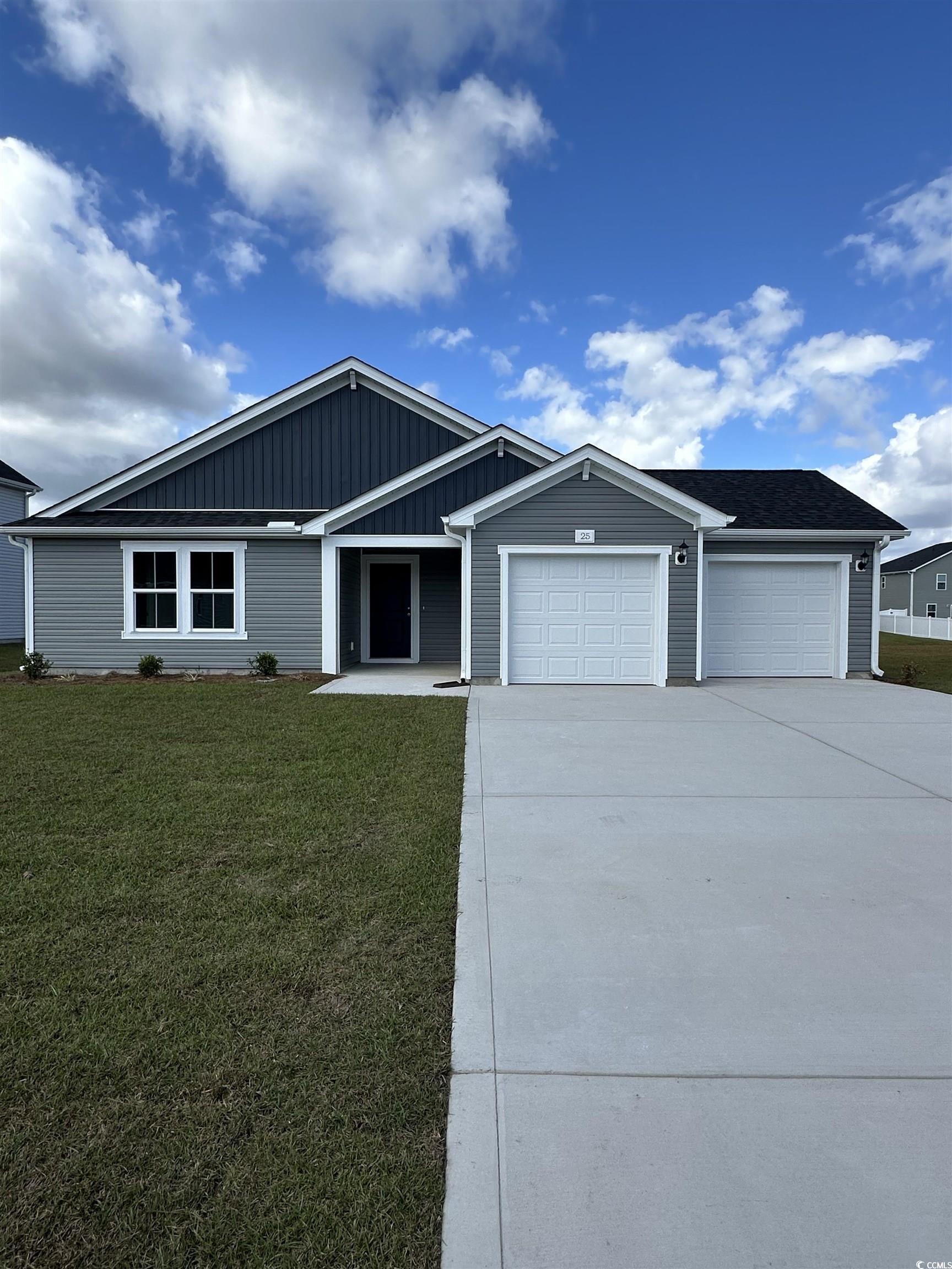 View of front of property with driveway, an attached garage, a front yard, a porch, and board and batten siding