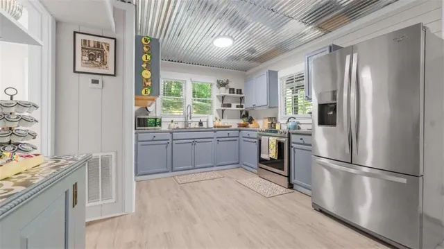 a kitchen with stainless steel appliances a refrigerator sink and cabinets