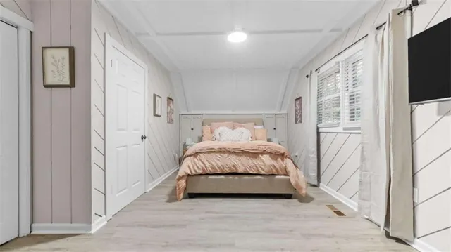 a bedroom with a bed and a flat tv screen