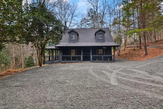 a front view of a house with a garden and trees