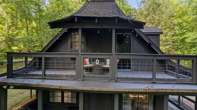 a view of house with wooden deck and furniture