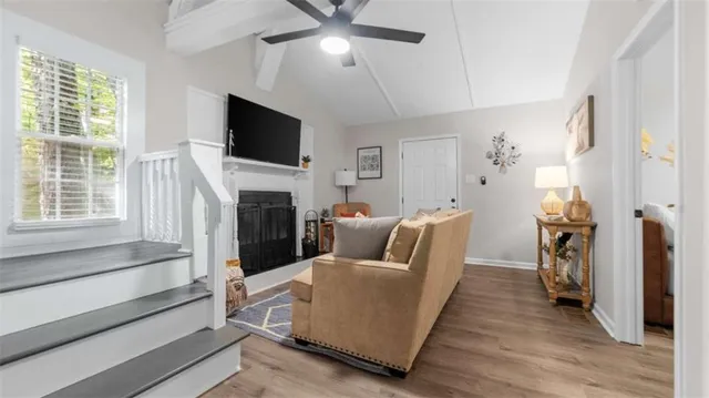 a living room with furniture a flat screen tv and a fireplace
