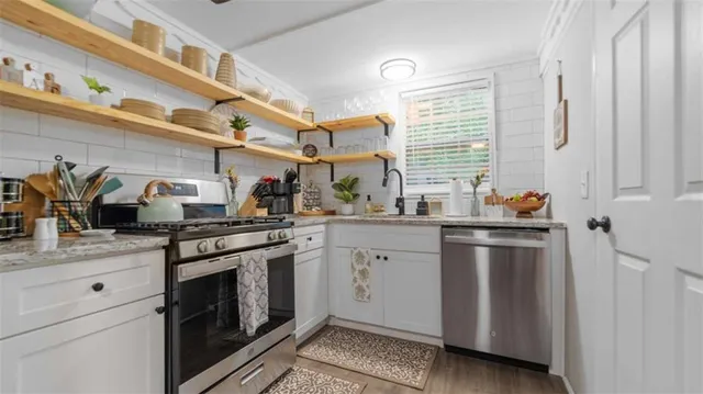 a kitchen with stainless steel appliances granite countertop a sink a stove and a refrigerator