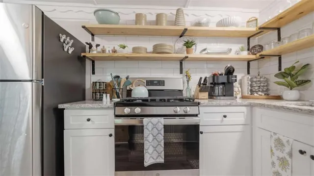 a kitchen with stainless steel appliances granite countertop a stove and a refrigerator