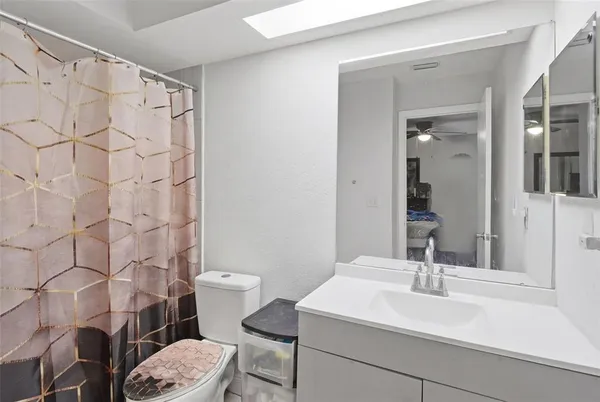 a bathroom with a sink a toilet and shower curtain