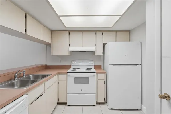 a kitchen with white cabinets sink and stove