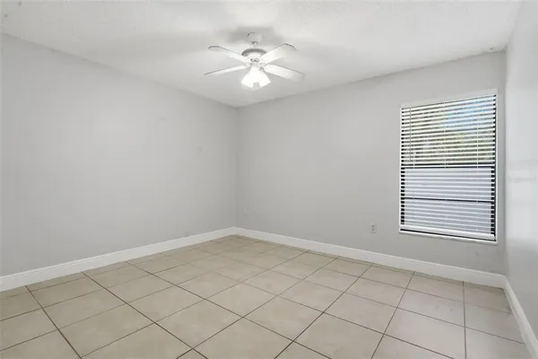 an empty room with windows and fan