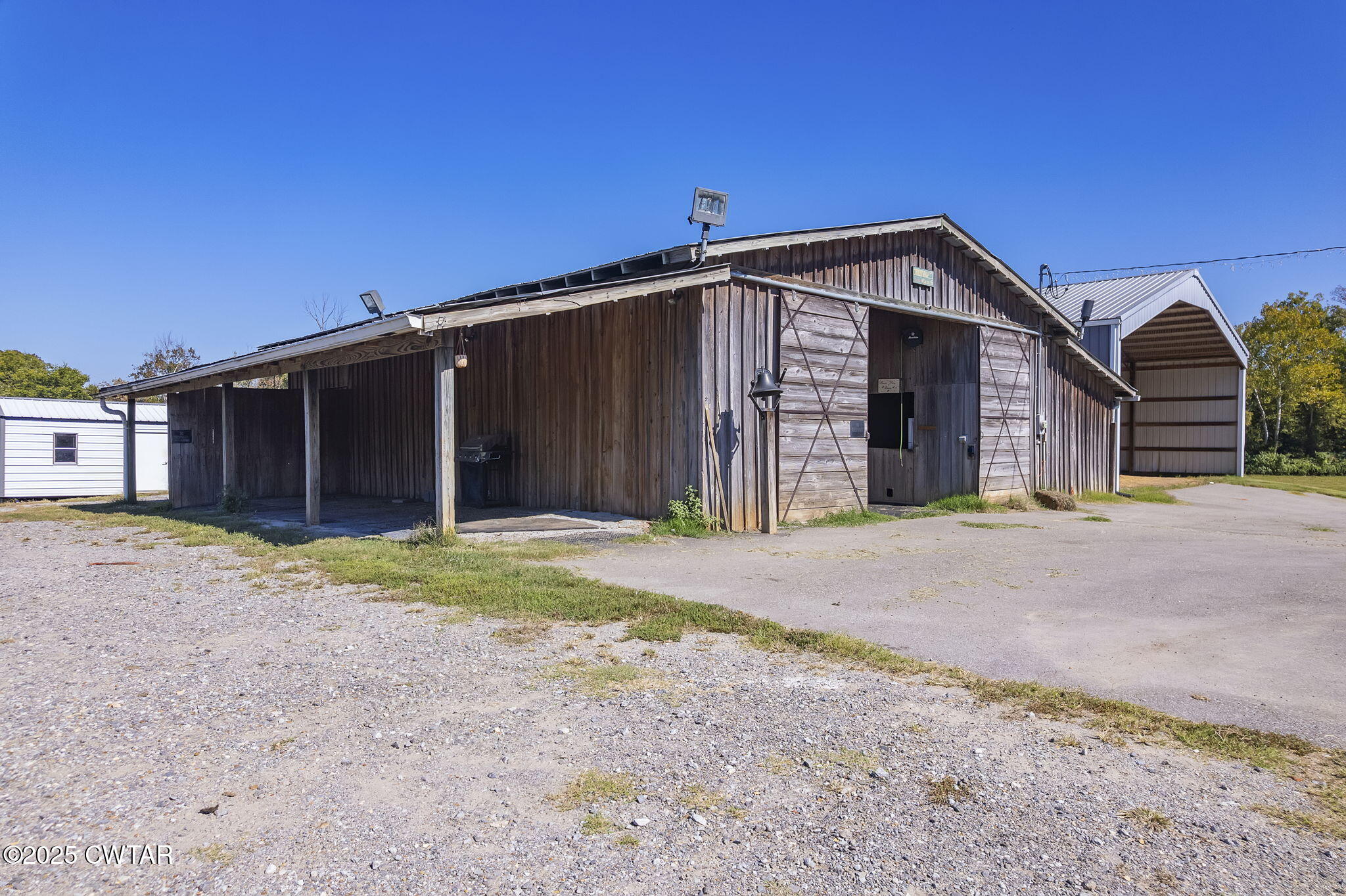 a view of a wooden house with a yard and large tree