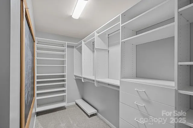 a view of walk in closet with empty racks