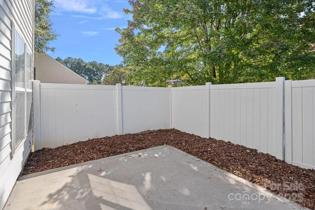 a view of a house with a small yard and wooden fence