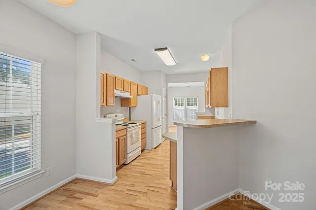 a kitchen with stainless steel appliances granite countertop a sink and wooden cabinets