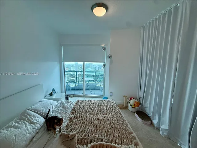 a bed sitting in a bedroom next to a window