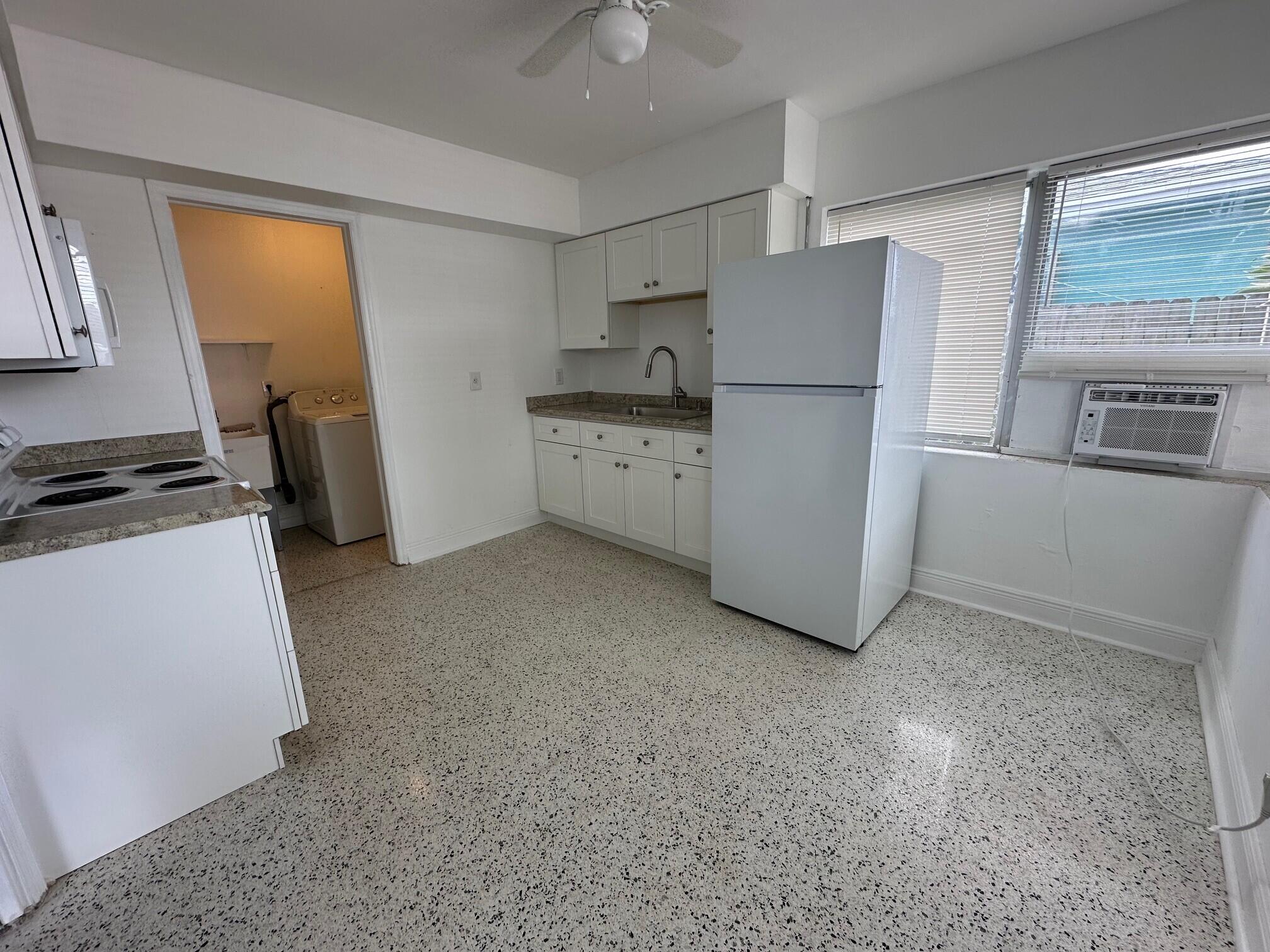1426 North J Street, Unit 1 Lake Worth Beach, FL 33460 - Photo 5 of 9 a kitchen with a refrigerator a stove top oven a sink and dishwasher
