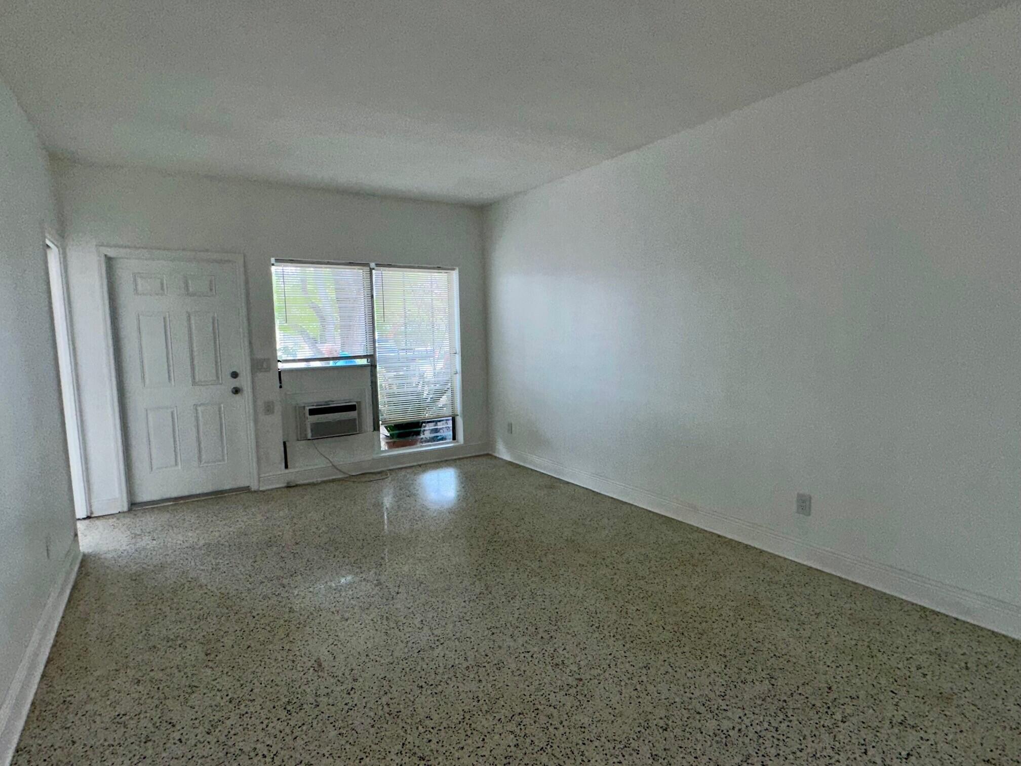 1426 North J Street, Unit 1 Lake Worth Beach, FL 33460 - Photo 6 of 9 an empty room with windows and closet