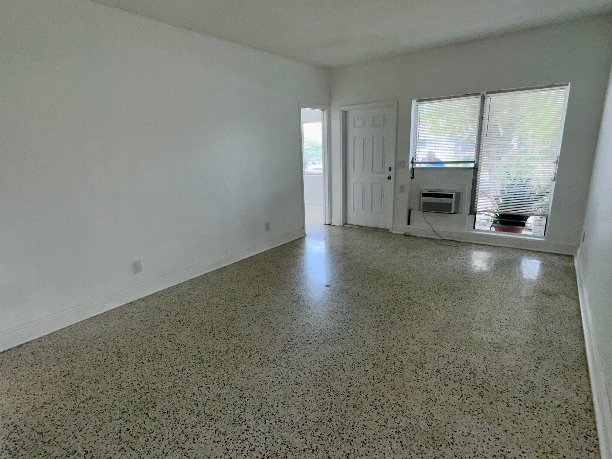 1426 North J Street, Unit 1 Lake Worth Beach, FL 33460 - Photo 7 of 9 an empty room with windows fireplace and windows