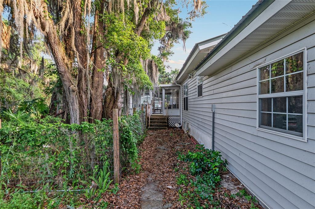 20361 1st Street McIntosh, FL 32664 - Photo 50 of 62 a view of a pathway of a house with plants and large trees