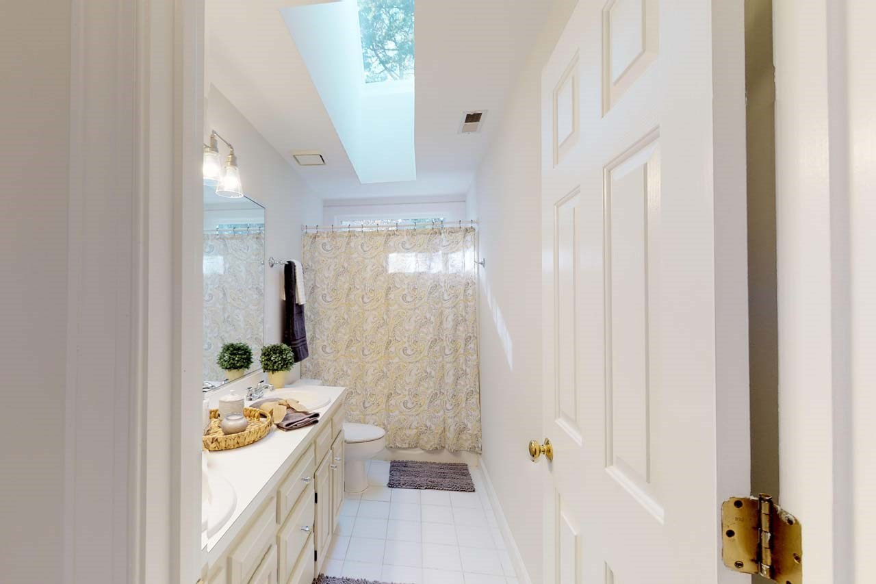 8601 Stanton Place Raleigh, NC 27615 - Photo 17 of 25 The hall bath features double vanity and a tub shower/ combo. The transom window and large sky light make this room bright and a great place to start your day! Bathroom