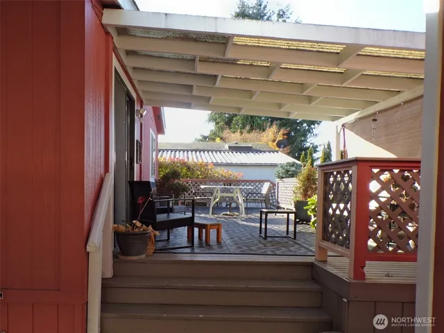 a view of a patio with table and chairs with wooden floor and plants