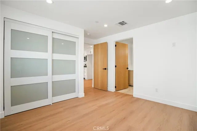 an empty room with wooden floor and closet